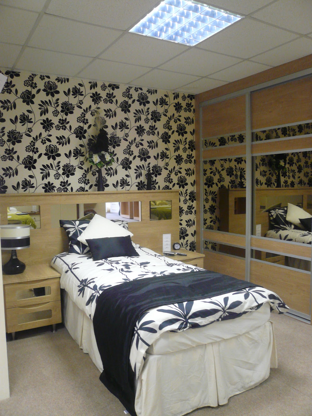 A bedroom set in our Drayton Road showroom, showing sliding wood-effect doors, bedsides and standalone pieces the way they look in a real room.